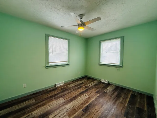 a view of a room with a ceiling fan and a window