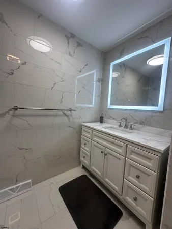 a spacious bathroom with a granite countertop sink a toilet and a mirror
