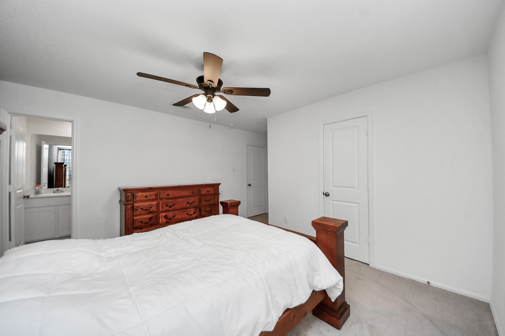 22828 Great Egret Drive Splendora, TX 77372 - Photo 14 of 39 a bedroom with a large bed and a chandelier