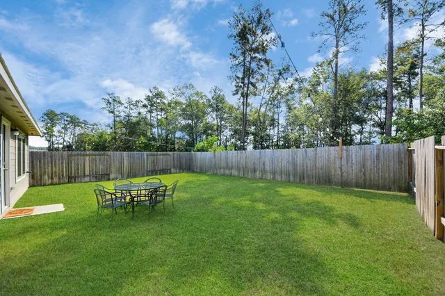 a backyard of a house with table and chairs