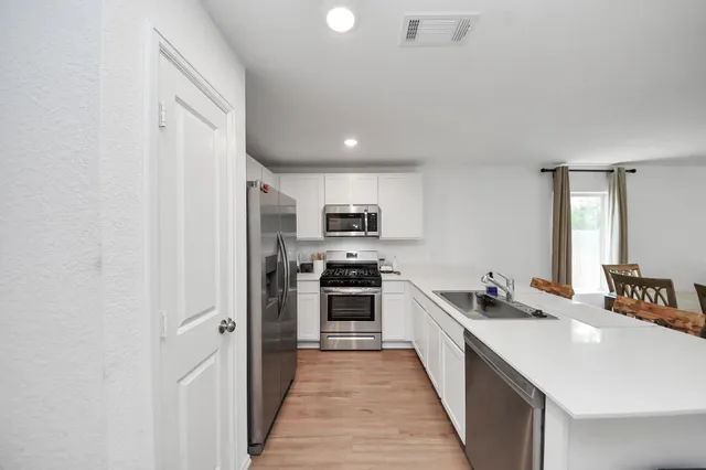 a large kitchen with a stove top oven a sink and dishwasher