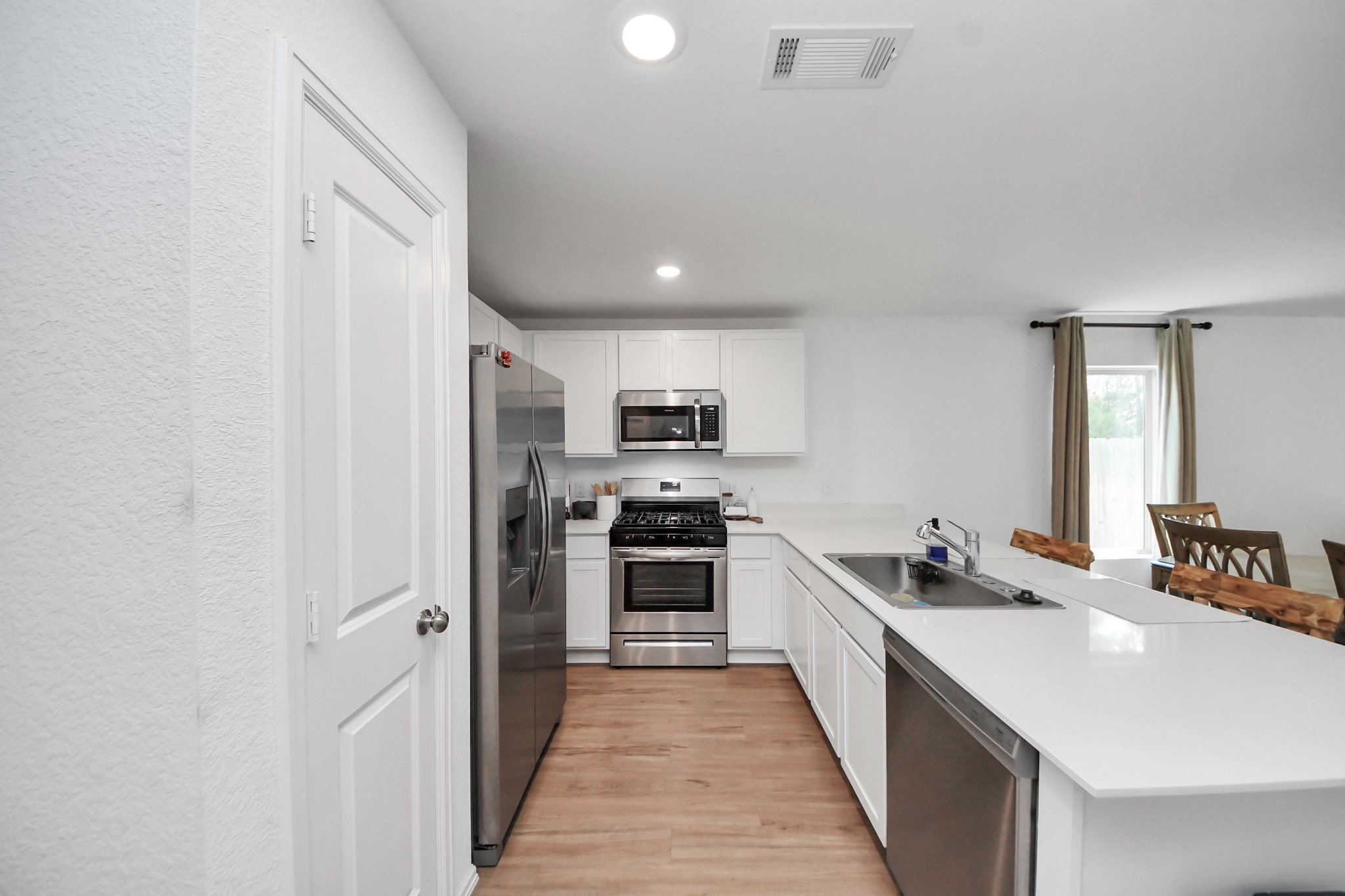 22828 Great Egret Drive Splendora, TX 77372 - Photo 34 of 39 a large kitchen with a stove top oven a sink and dishwasher