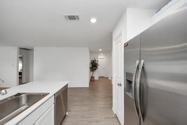 a kitchen with stainless steel appliances granite countertop a refrigerator and a sink