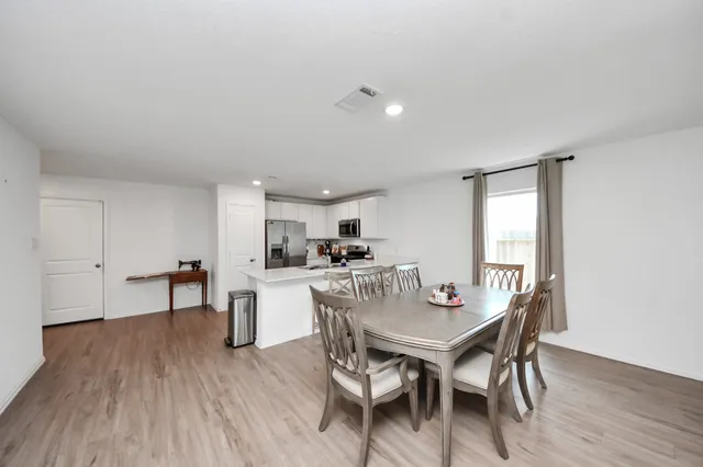 a dining room with furniture and wooden floor
