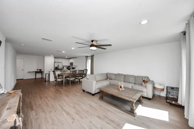 a living room with furniture and a wooden floor