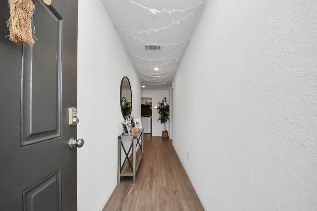 a view of a hallway with wooden floor and staircase