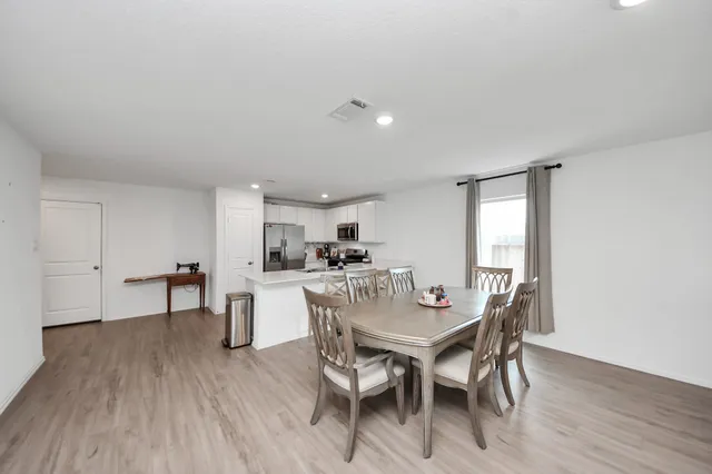 a dining room with furniture and wooden floor
