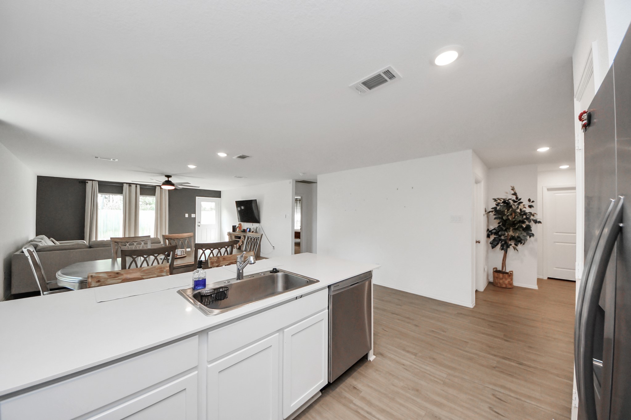 22828 Great Egret Drive Splendora, TX 77372 - Photo 9 of 39 a view of a kitchen with kitchen island a sink wooden floor and a potted plant