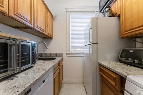 a kitchen with granite countertop a sink and a refrigerator