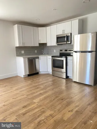 a kitchen with granite countertop white cabinets and stainless steel appliances