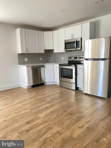 a kitchen with granite countertop white cabinets and stainless steel appliances