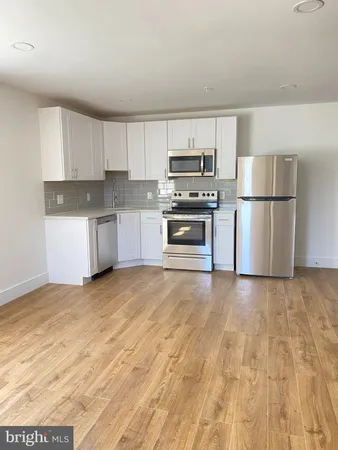 a kitchen with stainless steel appliances granite countertop a refrigerator sink and stove
