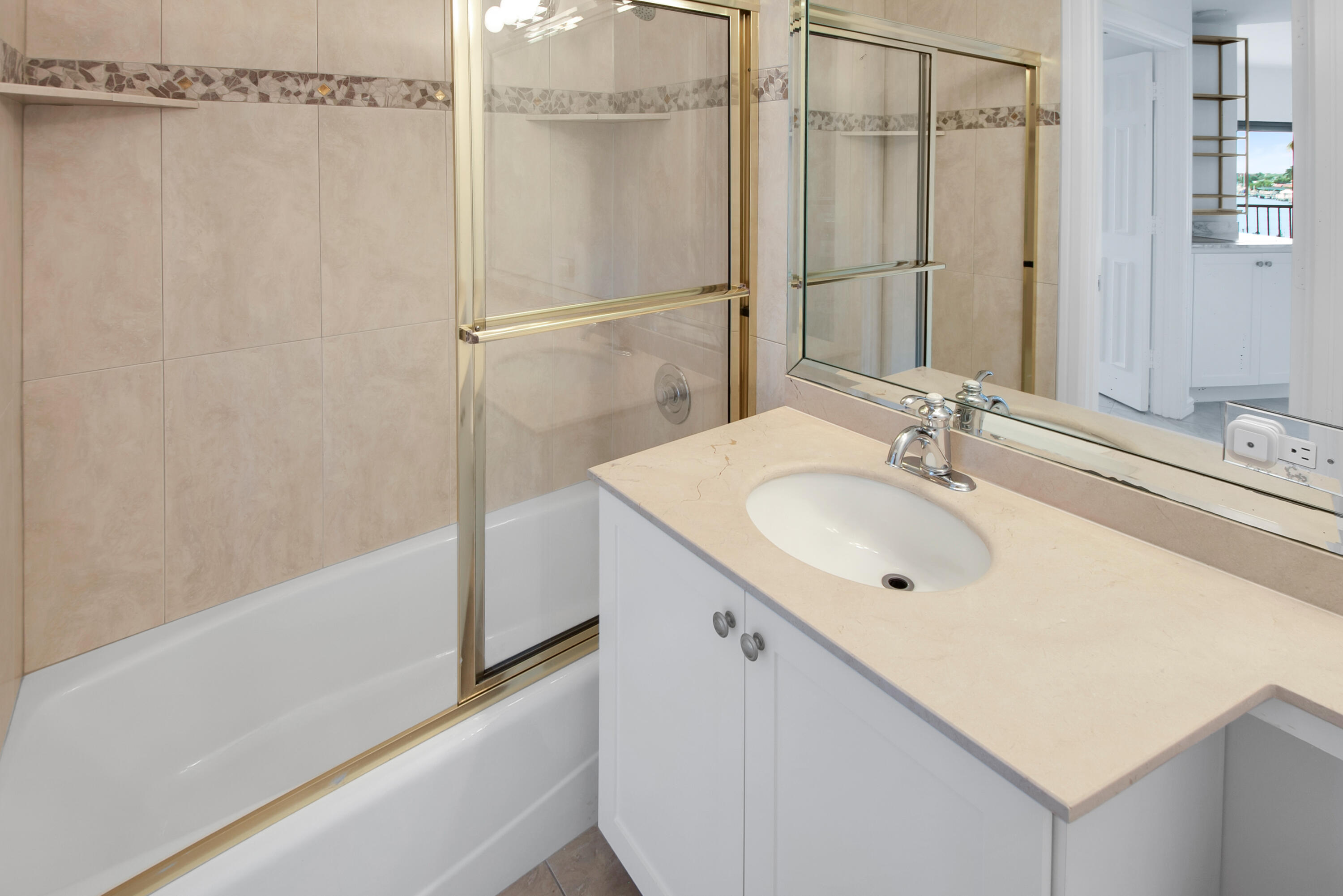 231 La Peninsula Boulevard, Unit 231 Naples, FL 34113 - Photo 16 of 42 a bathroom with a sink double vanity and shower
