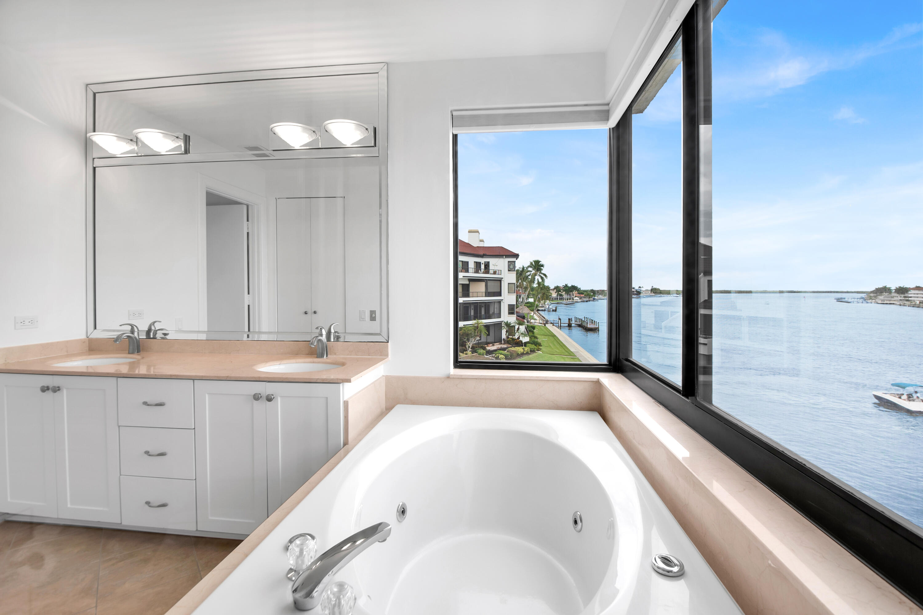 231 La Peninsula Boulevard, Unit 231 Naples, FL 34113 - Photo 21 of 42 a bathroom with a granite countertop sink and a large mirror