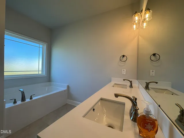 a bathroom with a tub sink and mirror