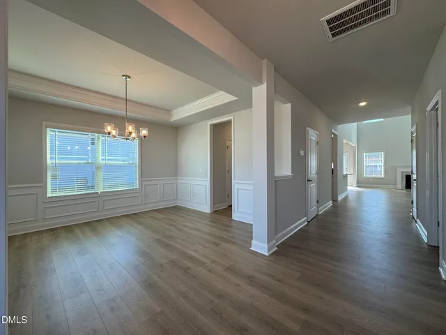 a view of a room with wooden floor kitchen and windows