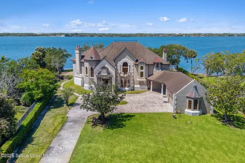 an aerial view of a house with a garden and lake view