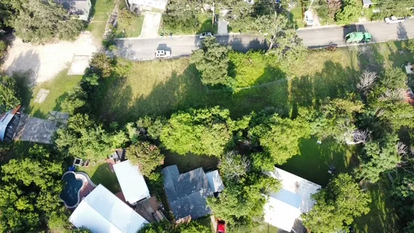 an aerial view of residential house with outdoor space and trees all around
