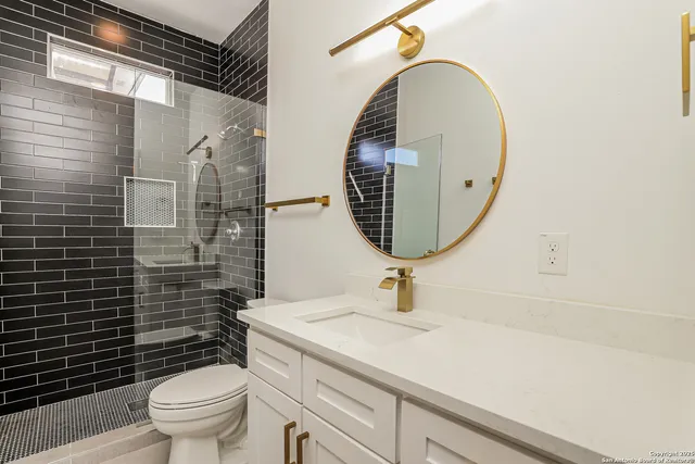 a bathroom with a toilet a sink and mirror