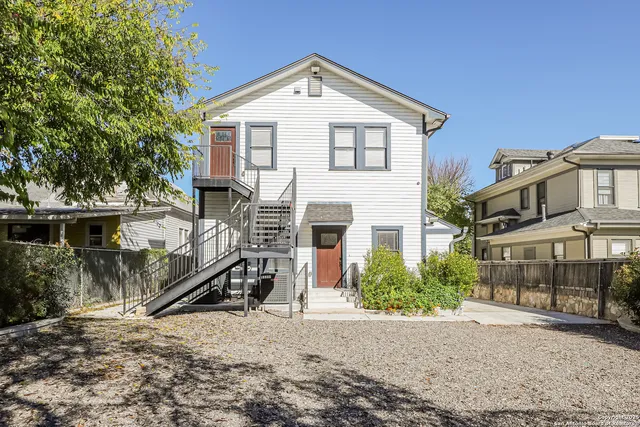 a view of a house with a yard and large tree