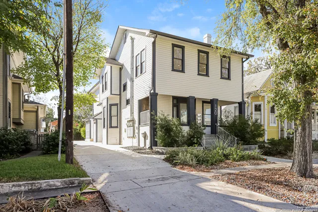 a front view of a house with a yard and trees