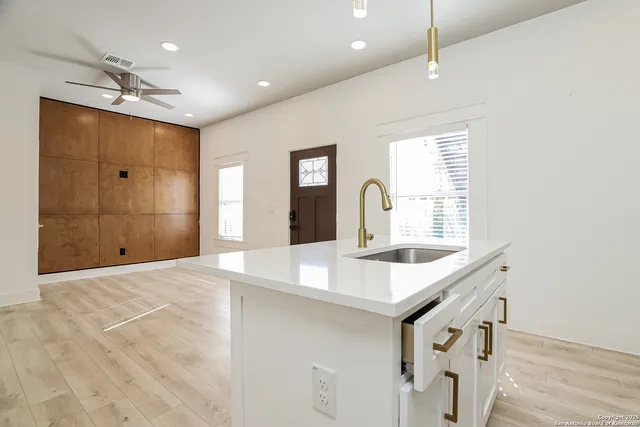 a kitchen with kitchen island a sink and a stove
