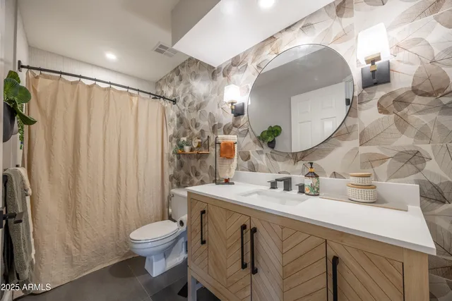a bathroom with a sink vanity mirror and toilet