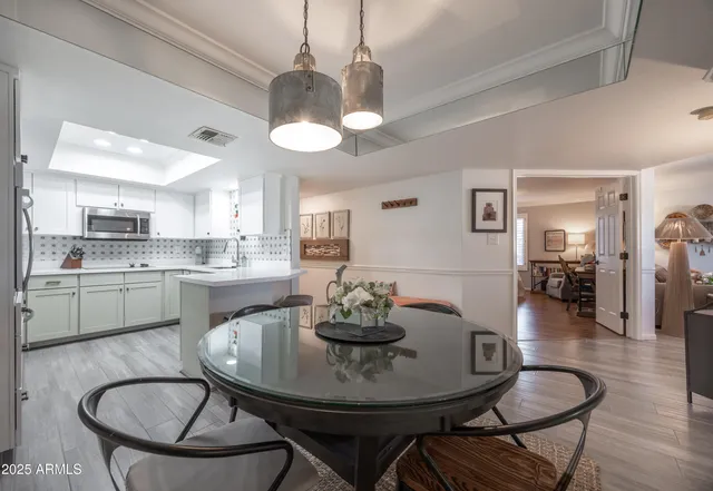 a view of a dining room with furniture a chandelier and wooden floor