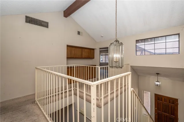 a view of staircase with railing and white walls