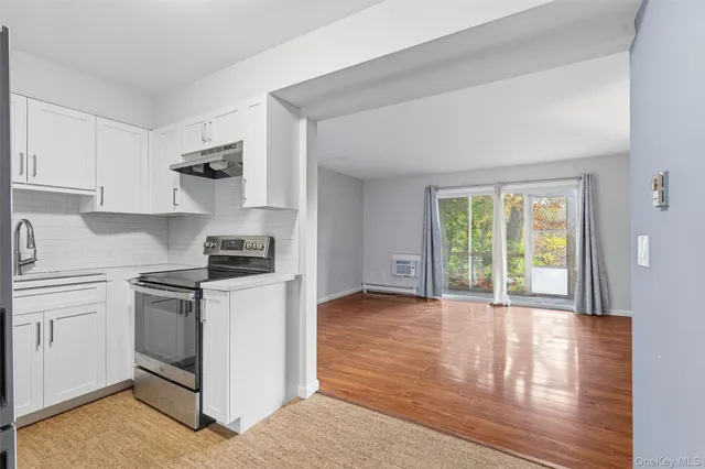 a kitchen with granite countertop a stove a sink and a refrigerator