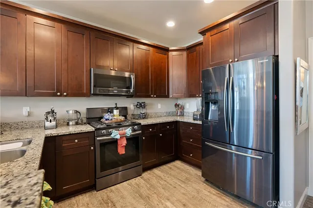 a kitchen with stainless steel appliances granite countertop a stove refrigerator and cabinets