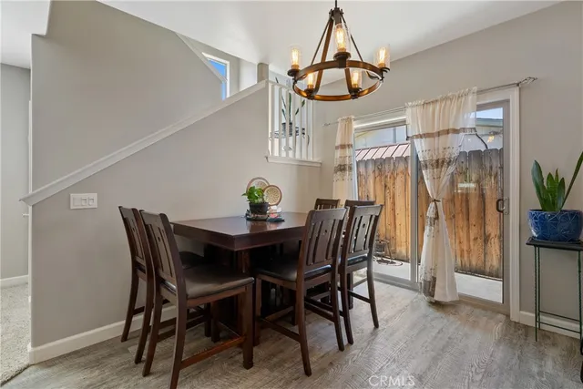 a view of a dining room and livingroom with furniture wooden floor a chandelier