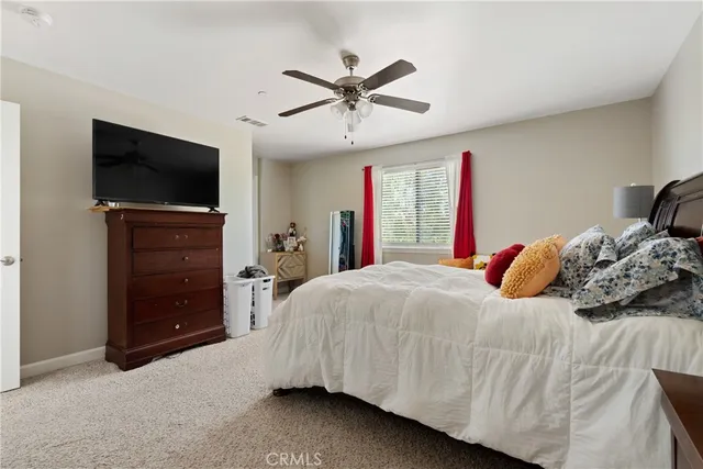 a bedroom with a bed and a flat tv screen on dresser