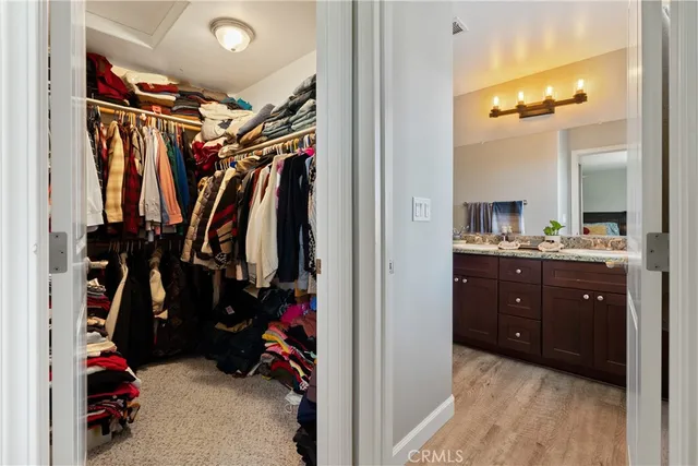 a view of walk in closet with clothes and shoes