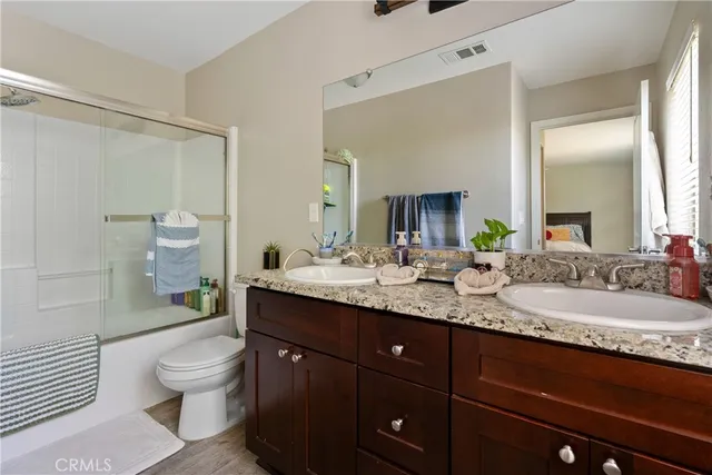 a bathroom with a granite countertop sink toilet a large mirror and shower