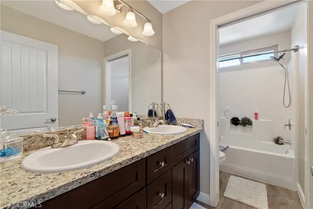 a bathroom with a granite countertop sink tub and a mirror