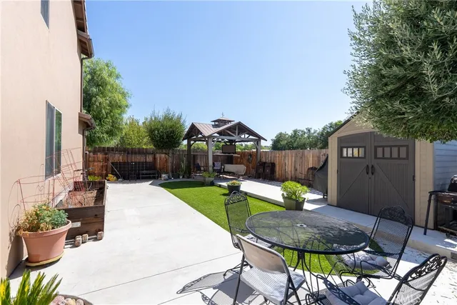 a view of a chairs and table in backyard