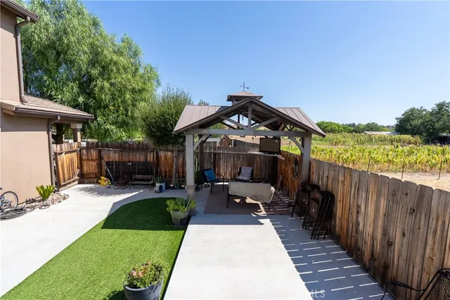 a view of a backyard with table and chairs and wooden fence