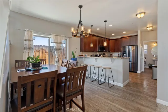 a dining room filled chandelier and wooden floors