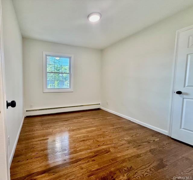30 7th Street Holbrook, NY 11741 - Photo 13 of 22 an empty room with wooden floor and windows
