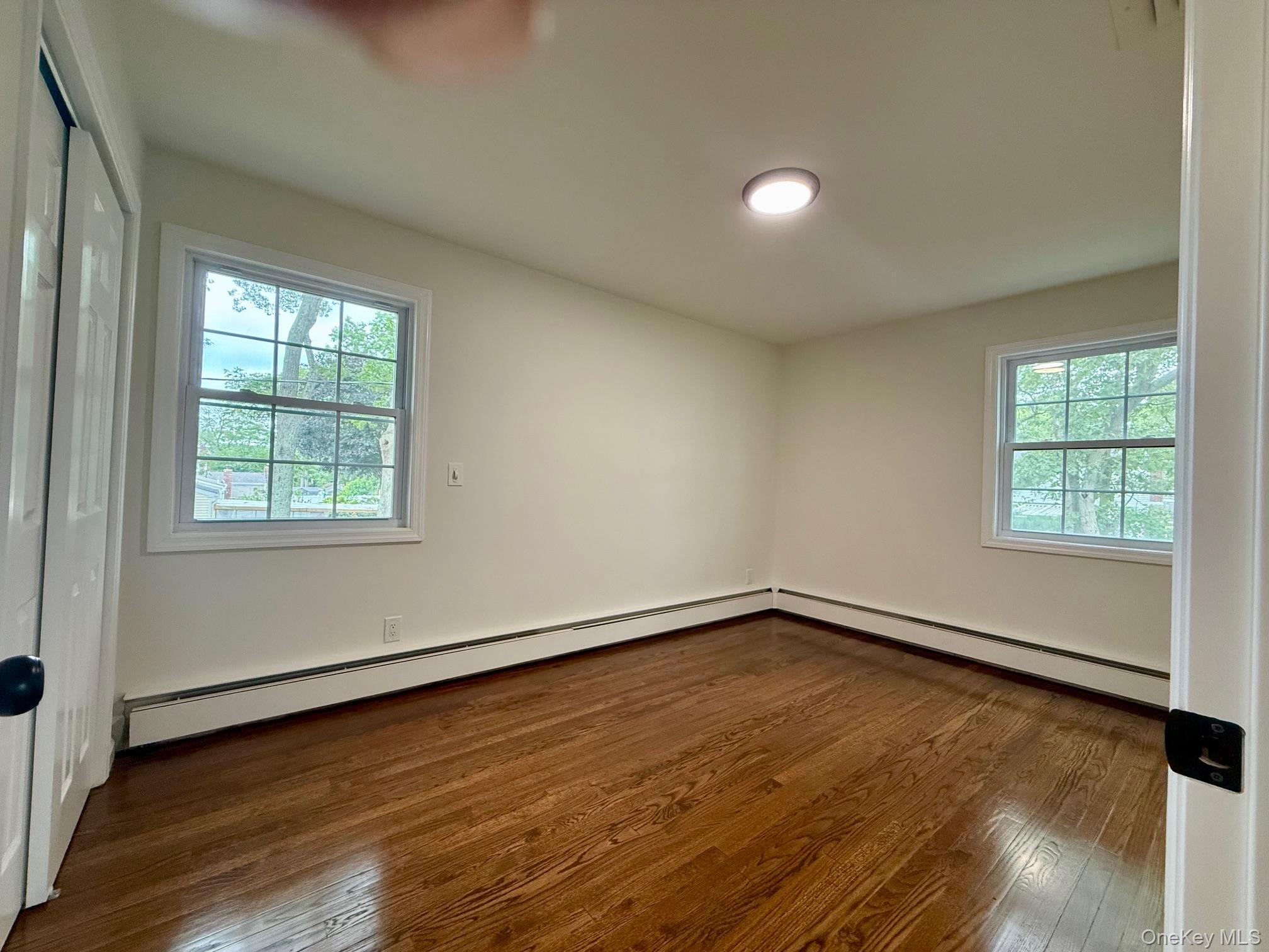 30 7th Street Holbrook, NY 11741 - Photo 15 of 22 an empty room with wooden floor and windows