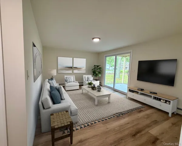 a living room with furniture a flat screen tv and a large window