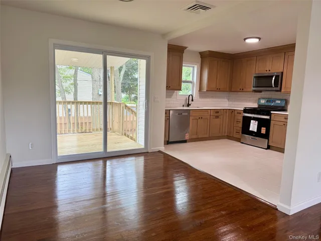 a large kitchen with a large window and stainless steel appliances