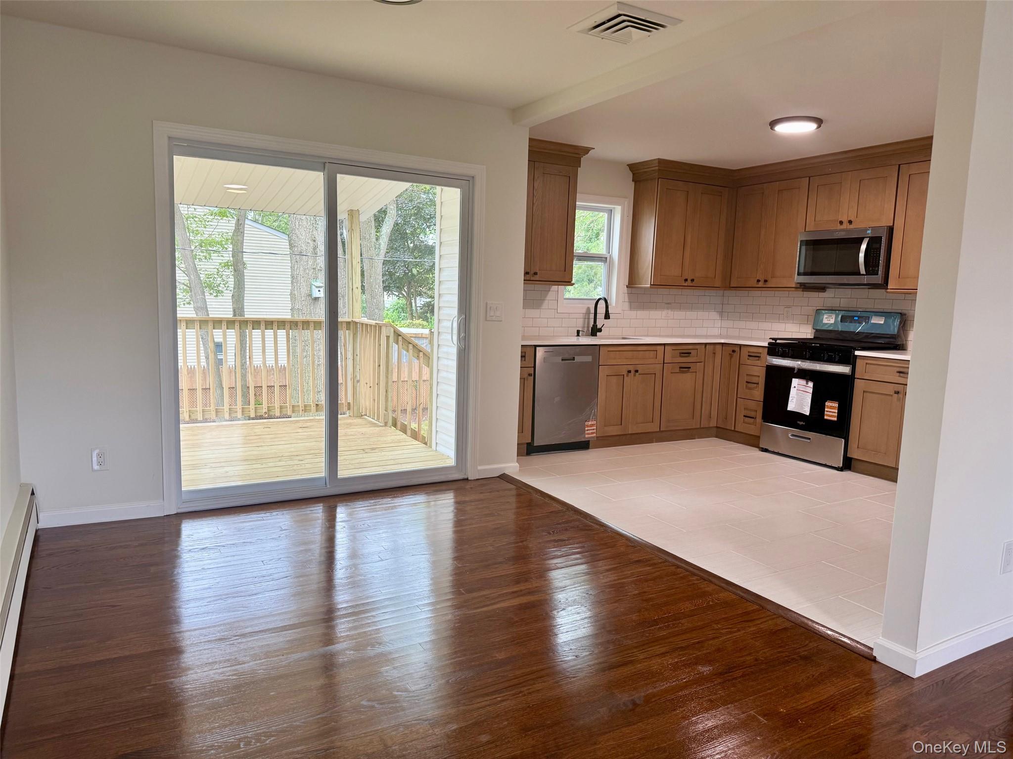30 7th Street Holbrook, NY 11741 - Photo 3 of 22 a large kitchen with a large window and stainless steel appliances