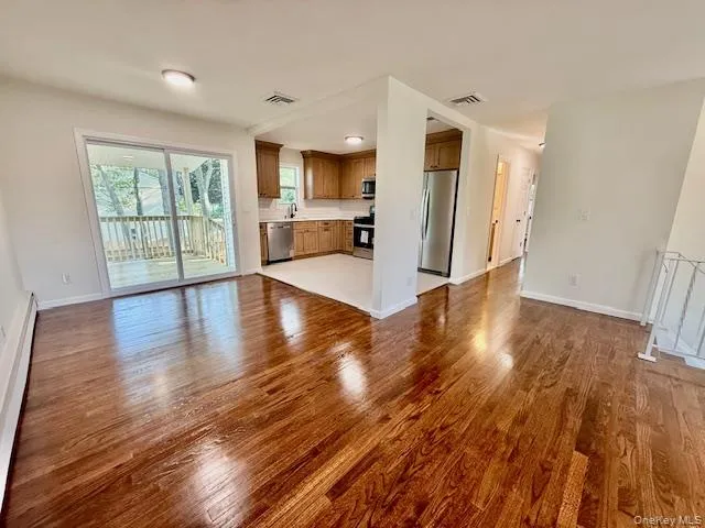 a view of a kitchen with wooden floor and a window