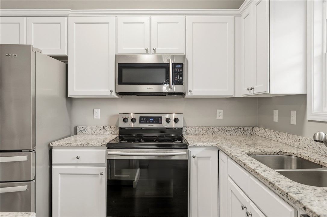 1411 Dunn Road Anderson, SC 29625 - Photo 13 of 30 This modern kitchen features crisp white cabinetry and bright countertops.