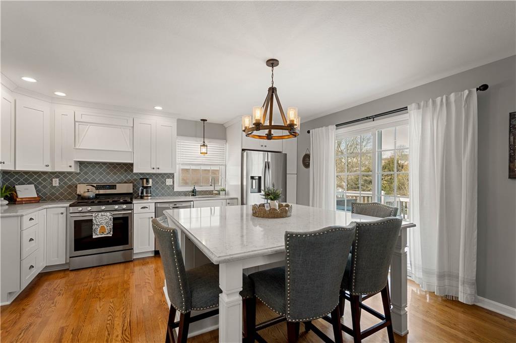 108 Walnut Drive Eighty Four, PA 15330 - Photo 12 of 47 a kitchen with granite countertop a stove a sink dishwasher a dining table and chairs with wooden floor