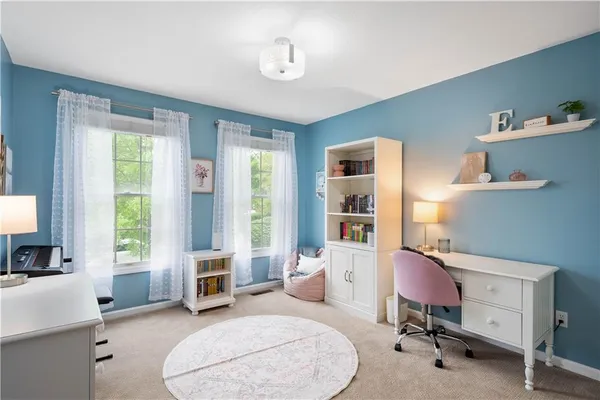 a view of a livingroom with workspace and a window