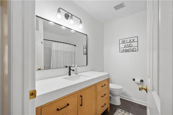 a bathroom with a sink a toilet and mirror