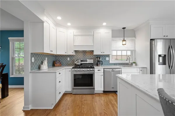a kitchen with stainless steel appliances granite countertop a stove a sink and a refrigerator